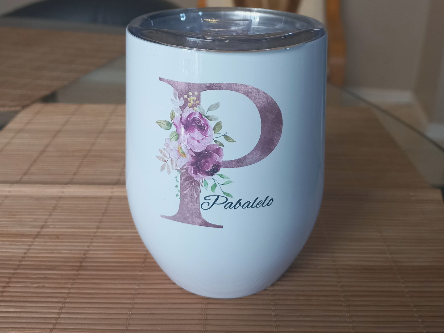 A white personalised tumbler printed with a mauve floral letter P and the name Pabalelo.