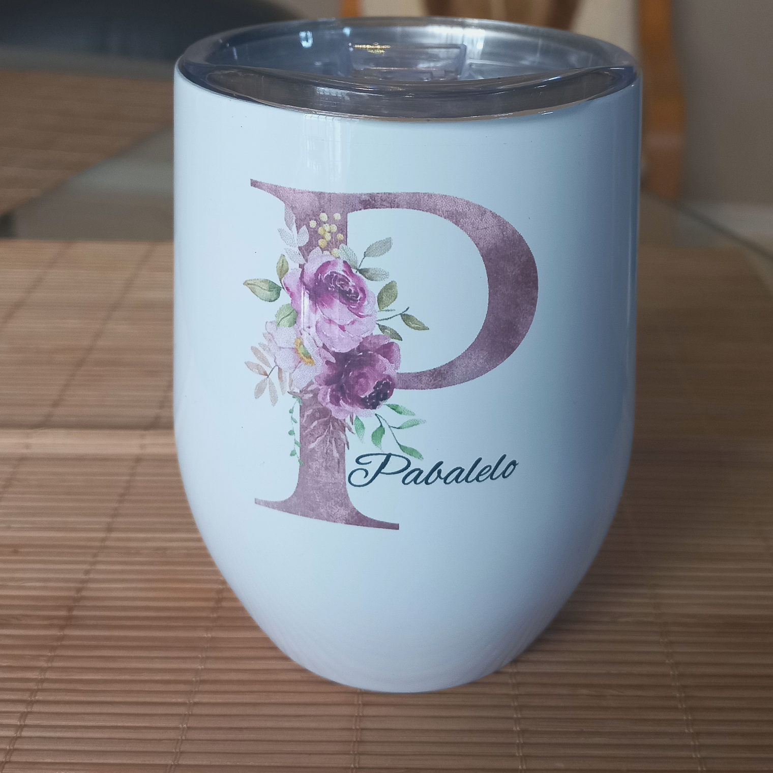 A white personalised tumbler printed with a mauve floral letter P and the name Pabalelo.